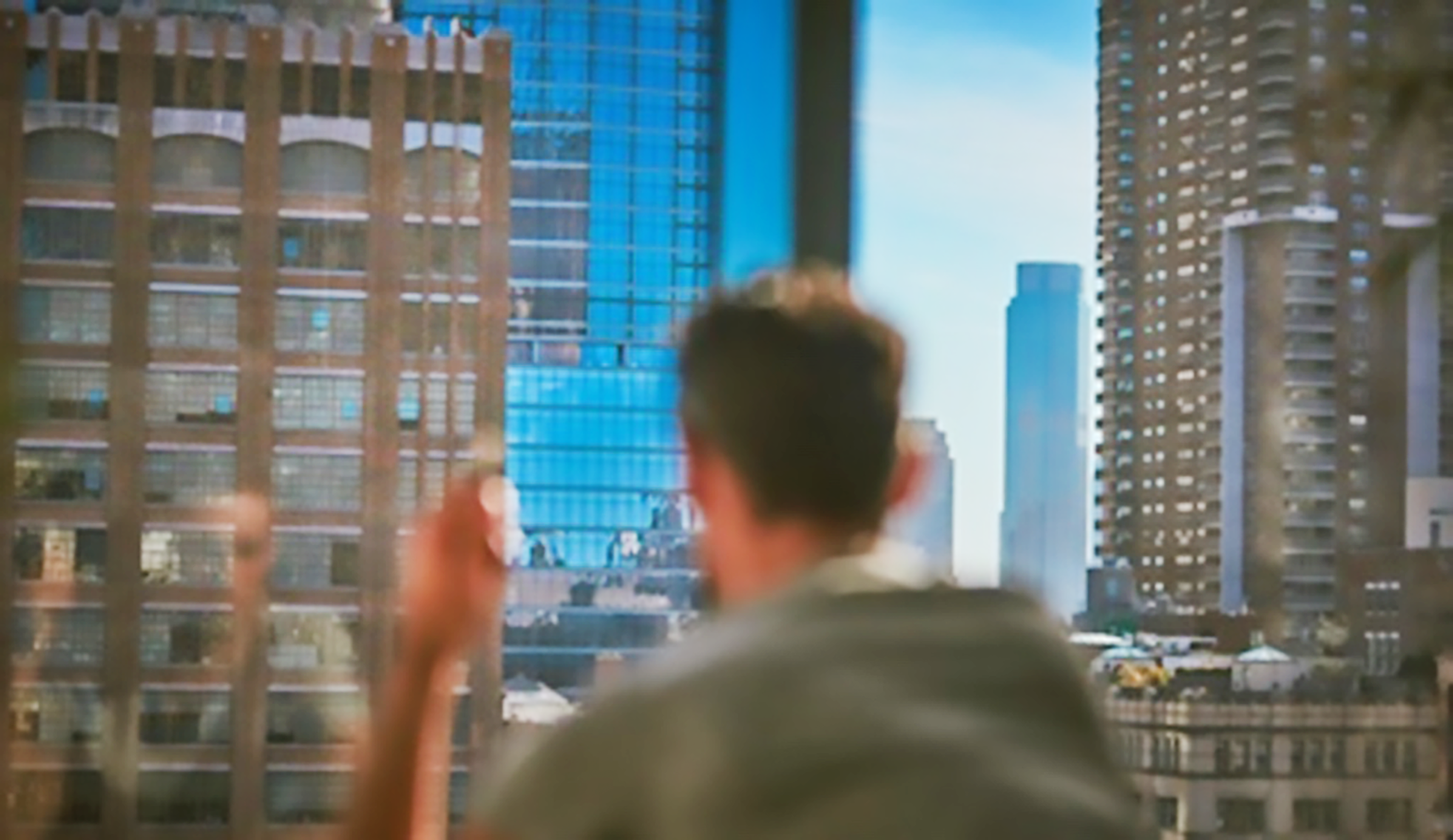 person sitting in front of laptop looking out over a cityscape